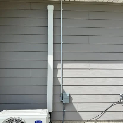 Exterior electrical equipment and conduit installed on a building wall